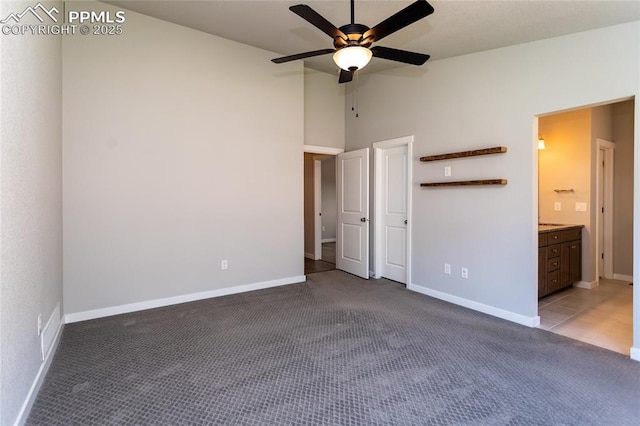 unfurnished bedroom featuring baseboards, carpet, and vaulted ceiling