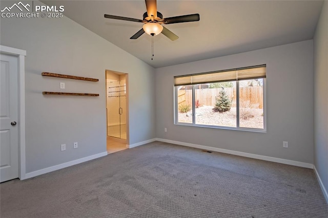 unfurnished bedroom featuring baseboards, carpet, ensuite bath, and vaulted ceiling
