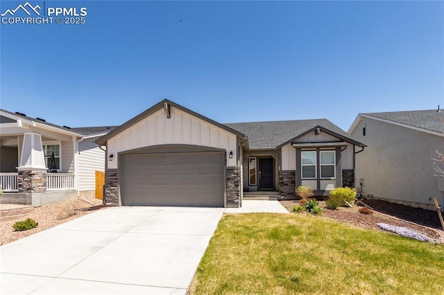 view of front of house featuring a garage, stone siding, a front yard, board and batten siding, and concrete driveway