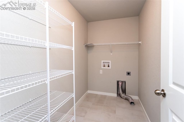 laundry room featuring light tile patterned flooring, laundry area, hookup for a washing machine, baseboards, and electric dryer hookup