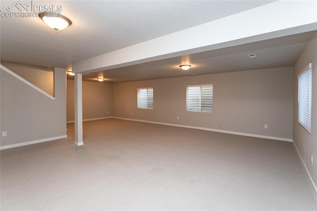 below grade area featuring baseboards and carpet