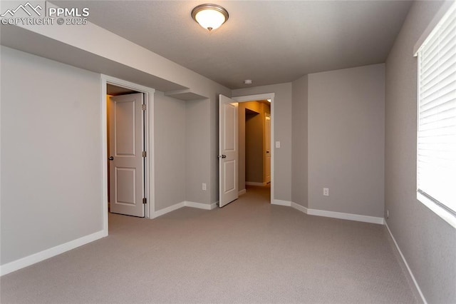 unfurnished bedroom featuring light colored carpet and baseboards