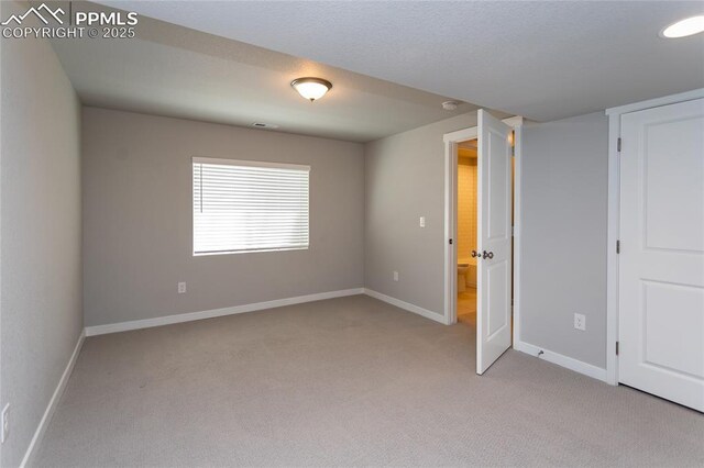 interior space featuring baseboards, light colored carpet, and visible vents