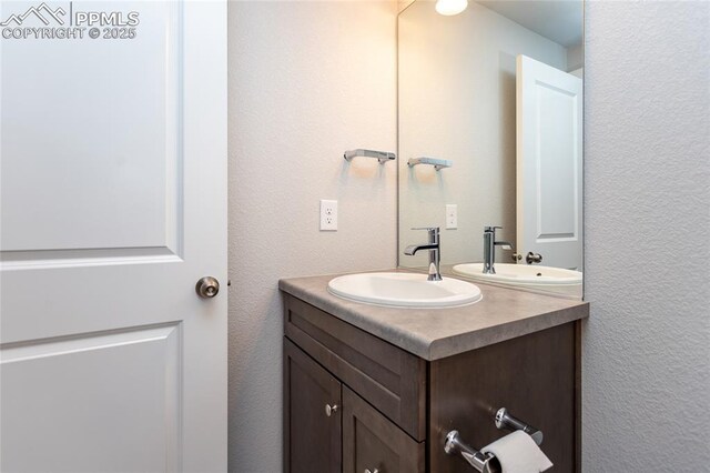 bathroom featuring vanity and a textured wall