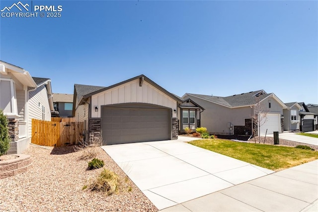 single story home featuring fence, stone siding, a garage, board and batten siding, and driveway
