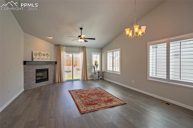 unfurnished living room with a fireplace, ceiling fan with notable chandelier, baseboards, lofted ceiling, and visible vents