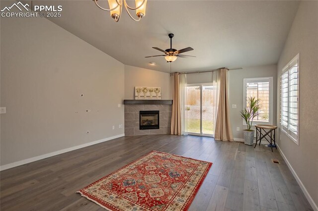 living room featuring vaulted ceiling, a ceiling fan, dark wood-style flooring, and a tile fireplace