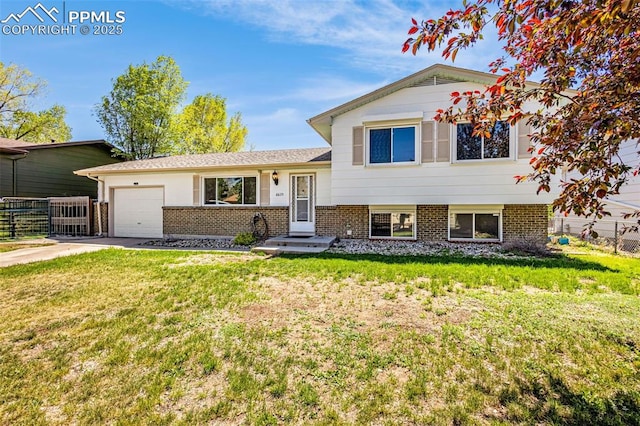 split level home with brick siding, fence, a front yard, and a garage
