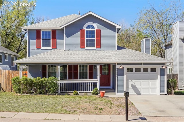 traditional home featuring an attached garage, fence, a front yard, concrete driveway, and a porch