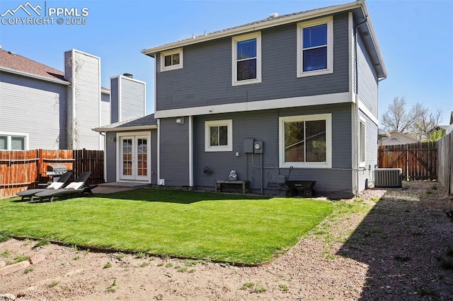 rear view of property with a lawn, central AC, french doors, and a fenced backyard
