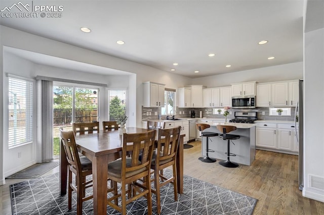 dining space with light wood-style floors, recessed lighting, and a healthy amount of sunlight