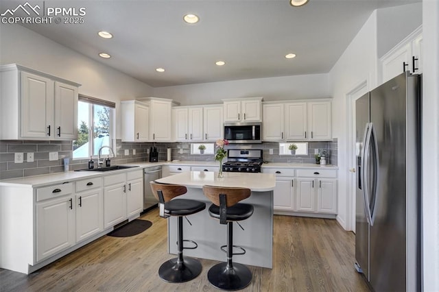 kitchen featuring stainless steel appliances, white cabinetry, a sink, and light wood-type flooring