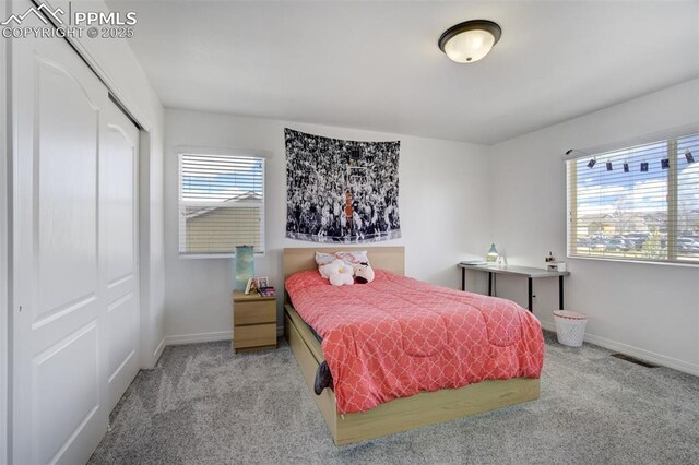 bedroom with baseboards, visible vents, carpet, and a closet