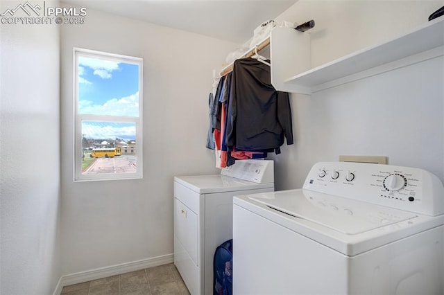 clothes washing area featuring baseboards, laundry area, and washer and clothes dryer