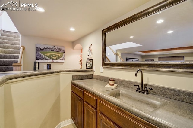 bar with stairs, recessed lighting, and a sink
