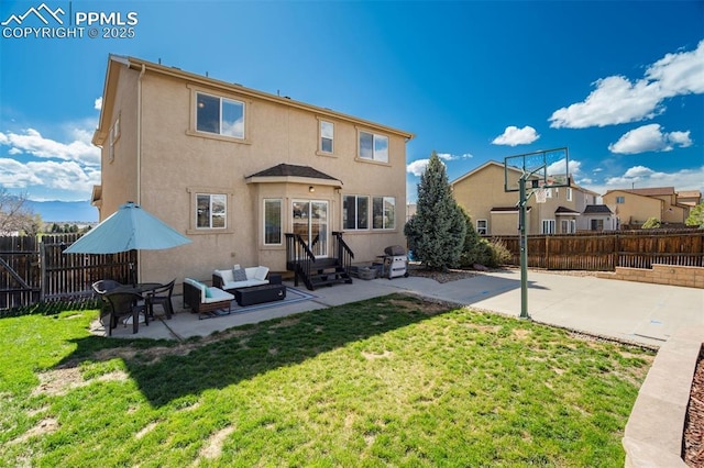 back of house featuring stucco siding, a fenced backyard, entry steps, a patio area, and a yard