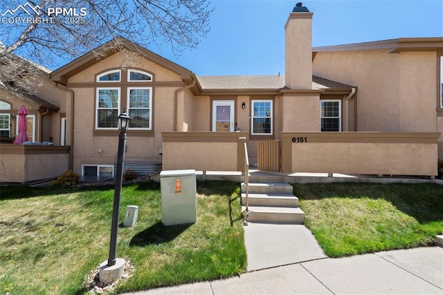 6151 Pine Hill Dr, Colorado Springs, CO 80918 - view of front of house with fence private yard, a front lawn, stucco siding, and a chimney