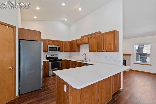 6151 Pine Hill Dr, Colorado Springs, CO 80918 - kitchen featuring brown cabinetry, a peninsula, dark wood-style floors, high vaulted ceiling, and stainless steel appliances