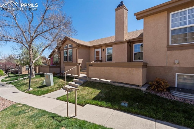 6151 Pine Hill Dr, Colorado Springs, CO 80918 - view of front of house with stucco siding, a front yard, and a chimney