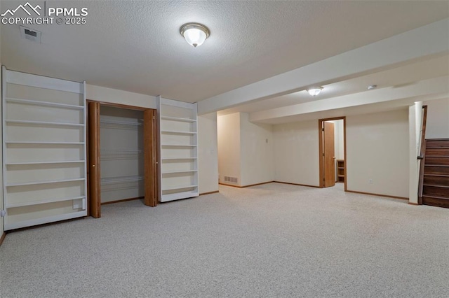6151 Pine Hill Dr, Colorado Springs, CO 80918 - finished basement featuring stairs, light colored carpet, a textured ceiling, and visible vents