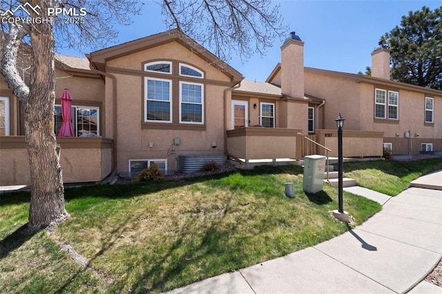6151 Pine Hill Dr, Colorado Springs, CO 80918 - view of front facade featuring central air condition unit, a front lawn, stucco siding, and a chimney