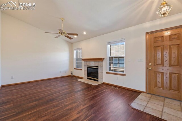 6151 Pine Hill Dr, Colorado Springs, CO 80918 - unfurnished living room with ceiling fan, vaulted ceiling, wood finished floors, a tile fireplace, and baseboards