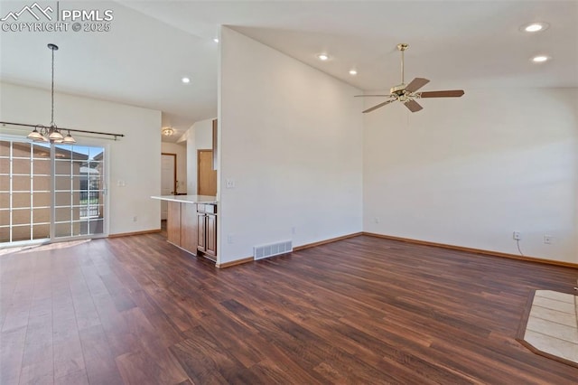 6151 Pine Hill Dr, Colorado Springs, CO 80918 - unfurnished living room with visible vents, baseboards, dark wood-style floors, ceiling fan with notable chandelier, and vaulted ceiling