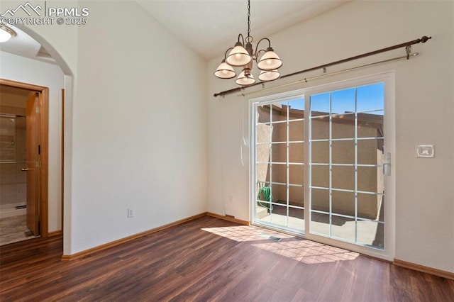 6151 Pine Hill Dr, Colorado Springs, CO 80918 - unfurnished dining area with an inviting chandelier, arched walkways, baseboards, dark wood-type flooring, and vaulted ceiling