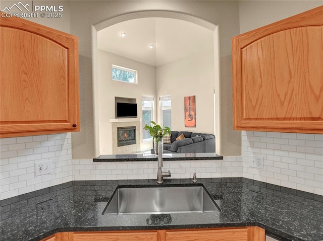 2174 Alpine Shadows Vw, Colorado Springs, CO 80919 - kitchen with a sink, a glass covered fireplace, and tasteful backsplash