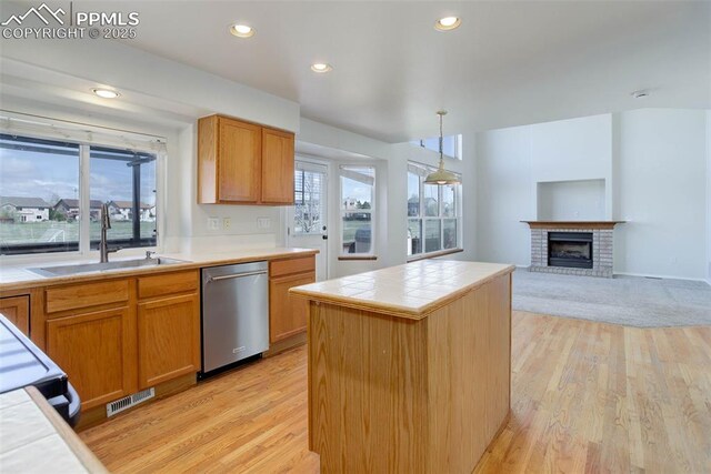 7884 Gladwater Rd, Peyton, CO 80831 - kitchen featuring stainless steel dishwasher, a sink, tile counters, and light wood-type flooring