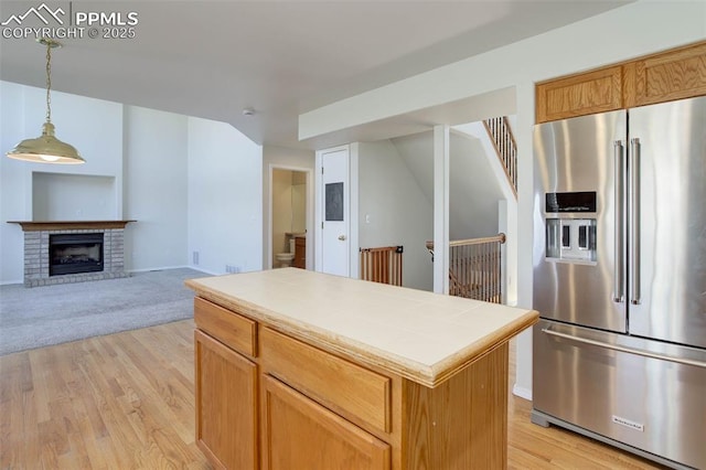 7884 Gladwater Rd, Peyton, CO 80831 - kitchen with pendant lighting, a kitchen island, high end fridge, tile countertops, and light wood finished floors