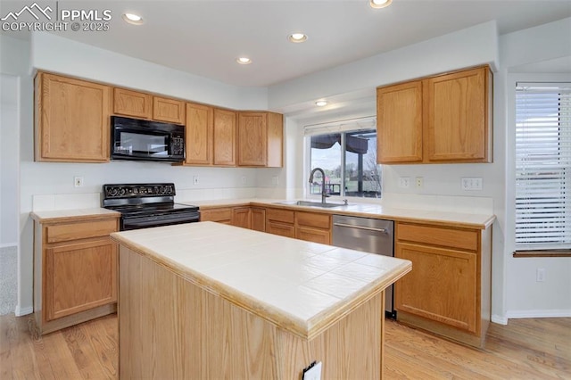 7884 Gladwater Rd, Peyton, CO 80831 - kitchen featuring tile counters, a center island, light wood-type flooring, a sink, and black appliances