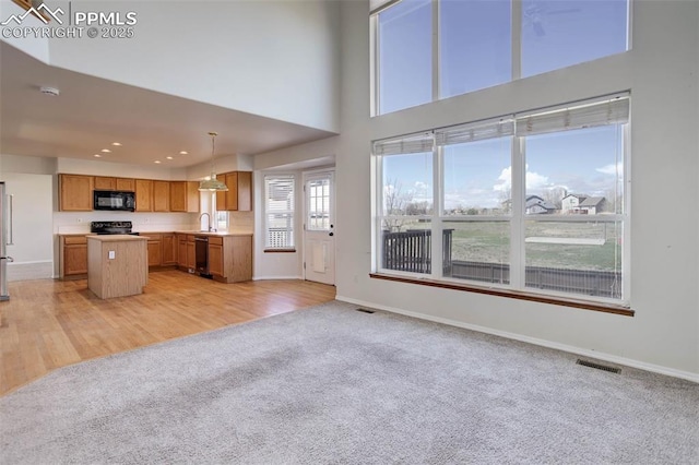 7884 Gladwater Rd, Peyton, CO 80831 - unfurnished living room featuring baseboards, recessed lighting, visible vents, and light carpet