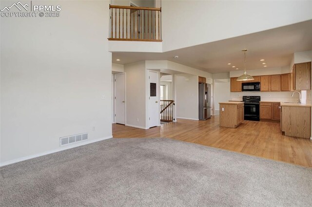7884 Gladwater Rd, Peyton, CO 80831 - unfurnished living room with visible vents, a sink, recessed lighting, and light carpet