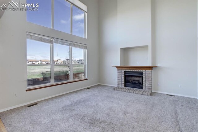7884 Gladwater Rd, Peyton, CO 80831 - unfurnished living room with baseboards, a high ceiling, carpet, and visible vents