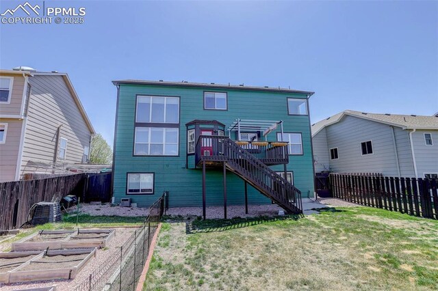 7884 Gladwater Rd, Peyton, CO 80831 - rear view of property with a fenced backyard, a wooden deck, a vegetable garden, and stairway