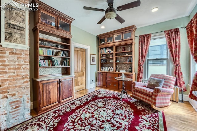 living area featuring baseboards, light wood-style flooring, recessed lighting, and a ceiling fan
