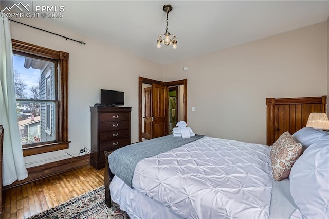 bedroom featuring a chandelier and hardwood / wood-style flooring