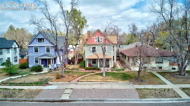 view of front of property with covered porch, a chimney, and a residential view