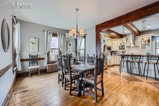 dining space with an inviting chandelier, radiator, baseboards, and light wood-type flooring