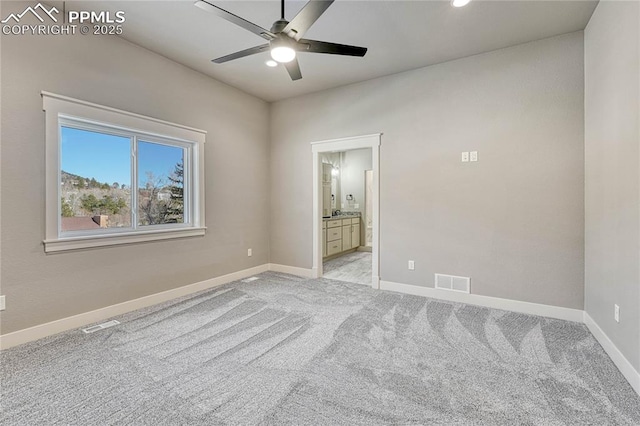 unfurnished bedroom with ensuite bath, light carpet, baseboards, and visible vents