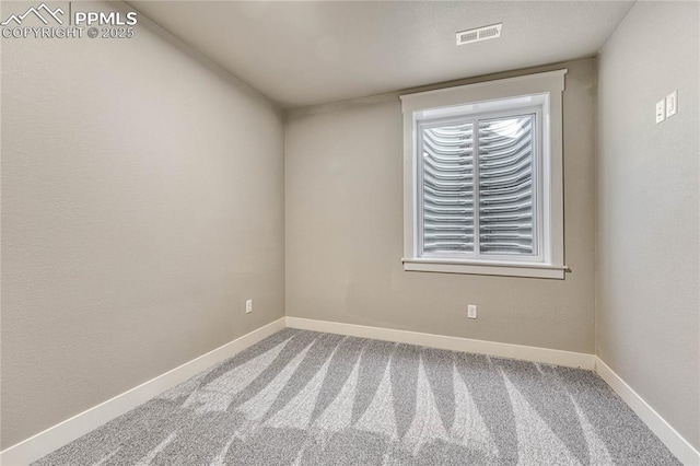 spare room with baseboards, carpet flooring, and visible vents
