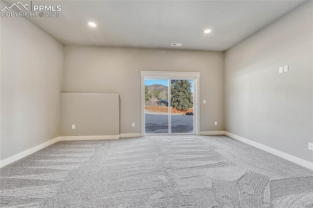 carpeted spare room featuring visible vents, baseboards, and recessed lighting