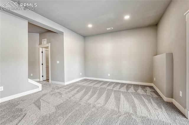 unfurnished room featuring carpet floors, baseboards, visible vents, and recessed lighting