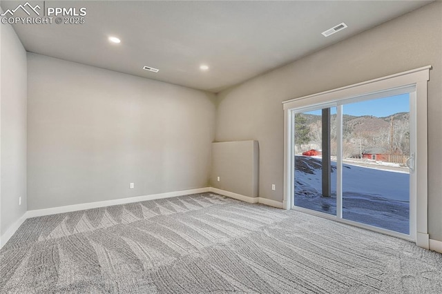 carpeted empty room with baseboards, visible vents, and recessed lighting