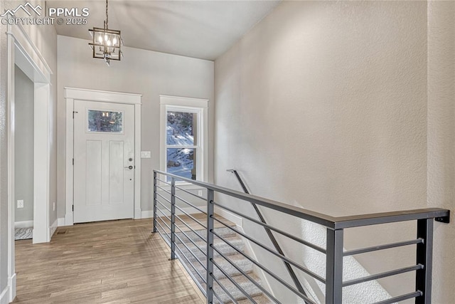 foyer featuring an inviting chandelier, wood finished floors, and baseboards
