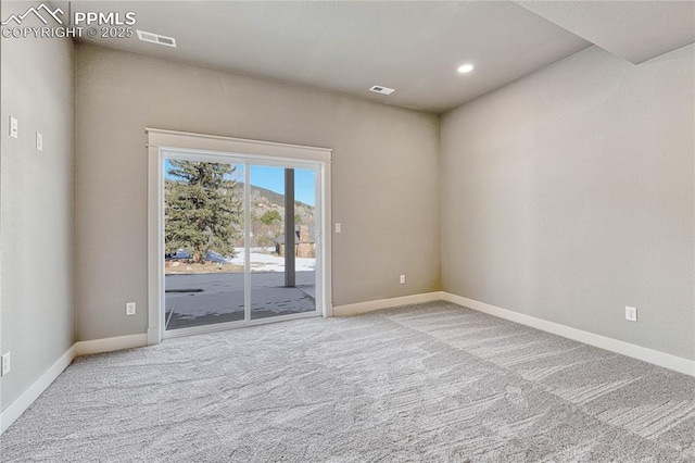 empty room with carpet floors, baseboards, and visible vents