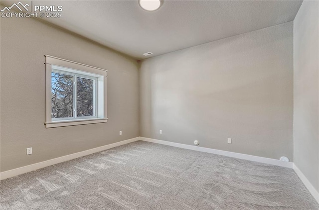 empty room featuring baseboards and carpet