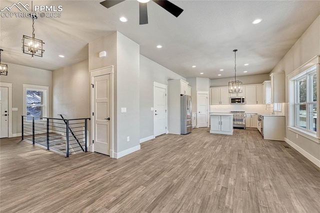 kitchen with baseboards, stainless steel appliances, and light wood-type flooring