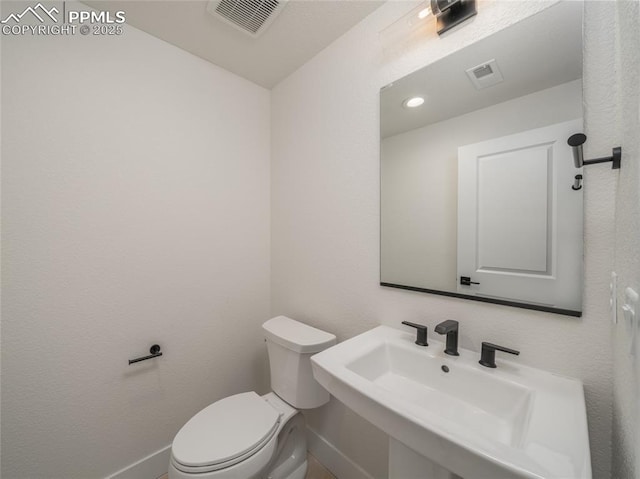 3188 Virga Loop, Colorado Springs, CO 80904 - half bath featuring baseboards, toilet, visible vents, and a sink